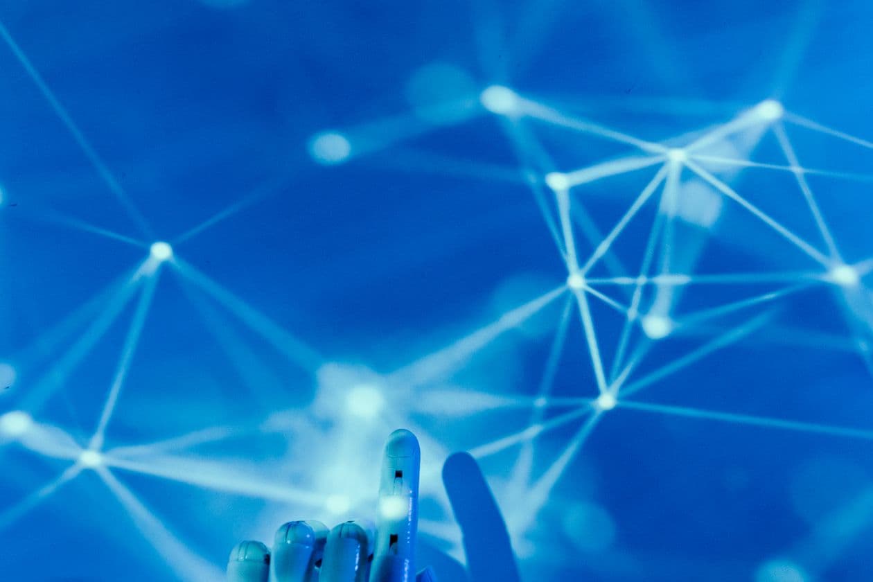 Robotic hand reaching toward a glowing digital network
