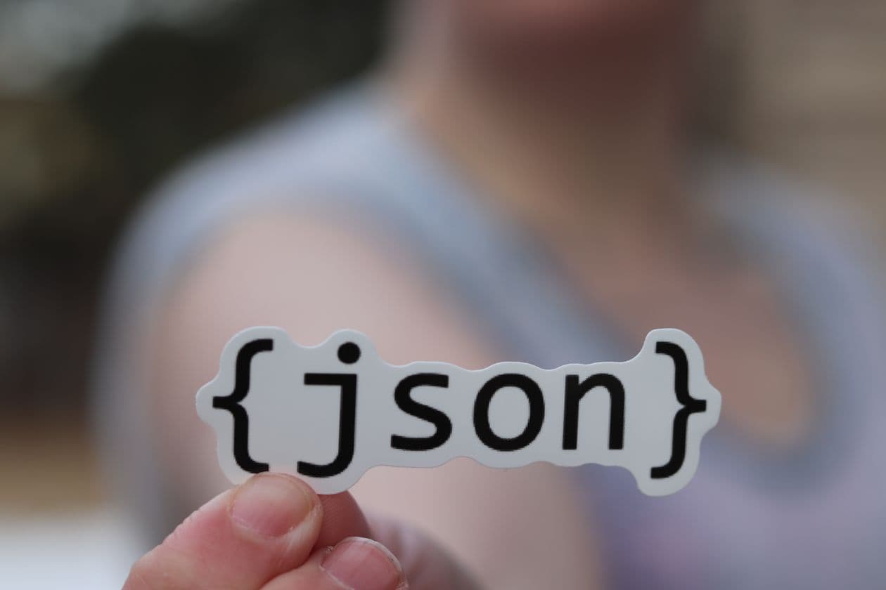 Hand holding a JSON sticker