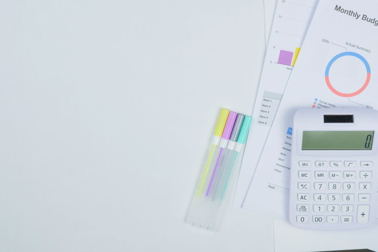 Calculator, pens, and budget planning sheets on a desk