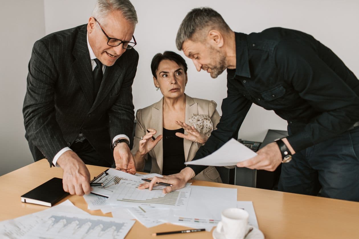 Colleagues comparing documents while making a business decision