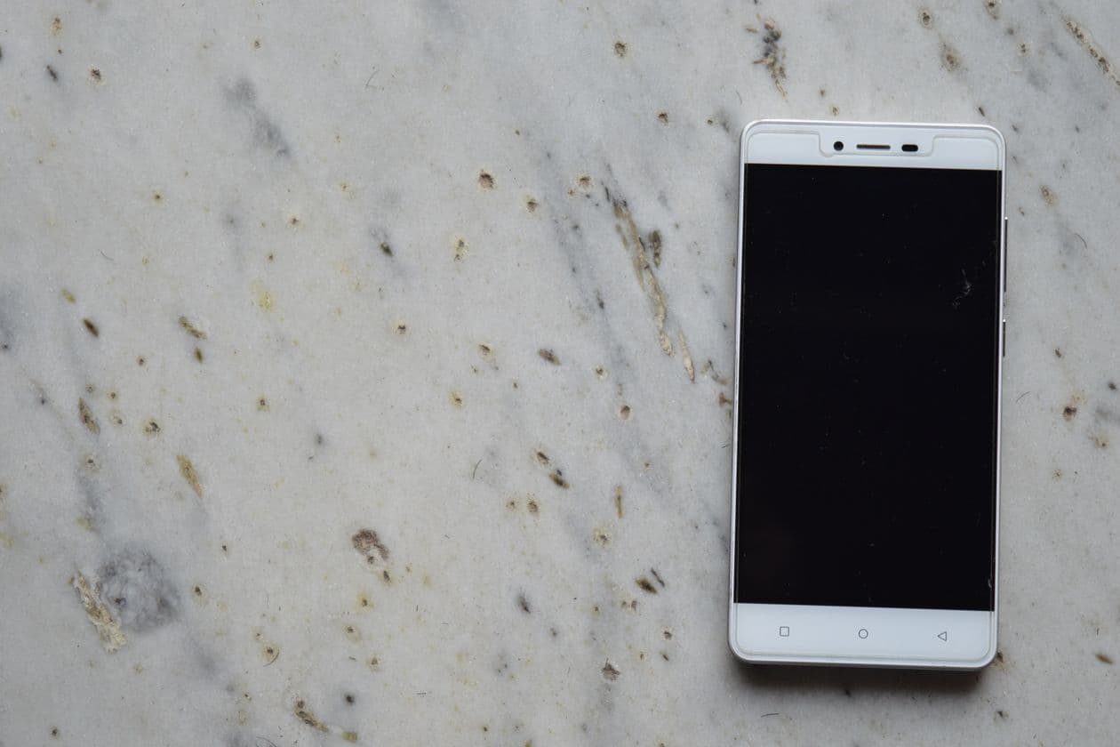 A smartphone lying face up on a marble surface