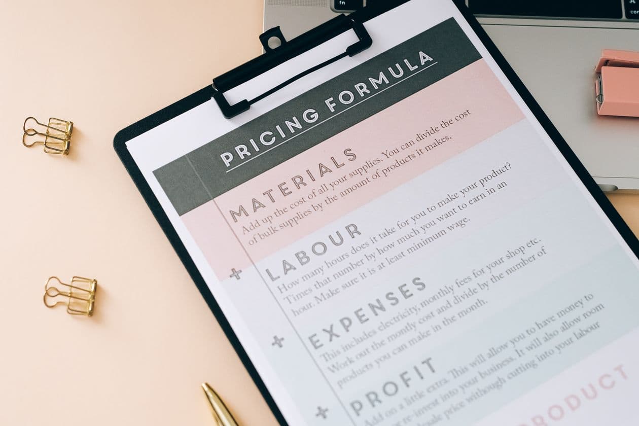 Clipboard with a pricing formula covering materials, labour, and expenses