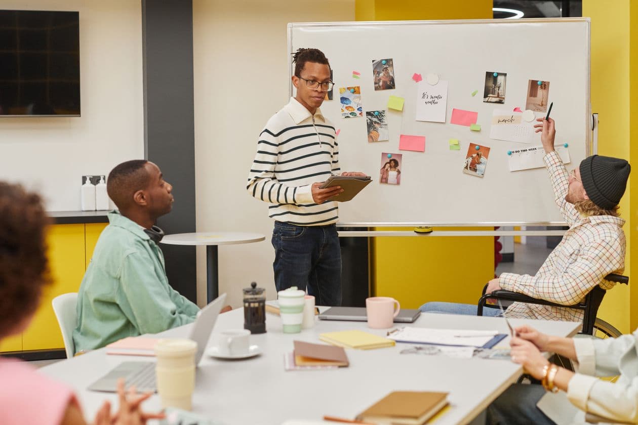 Product team meeting around a whiteboard covered in notes
