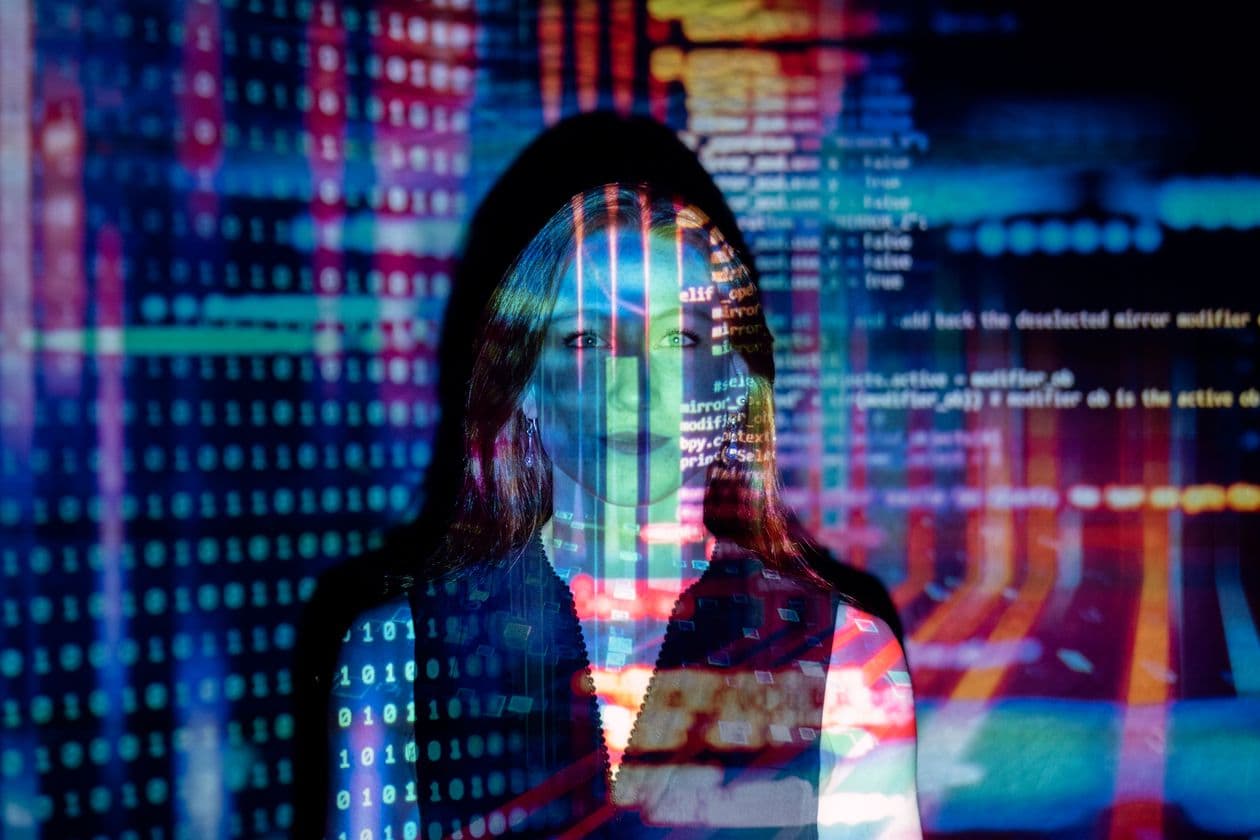 Face lit by projected lines of code and data