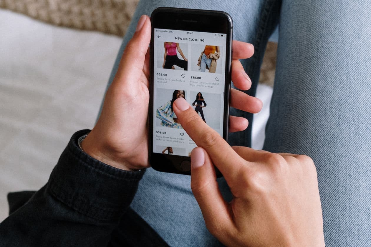 Person browsing clothes in a shopping app on a phone